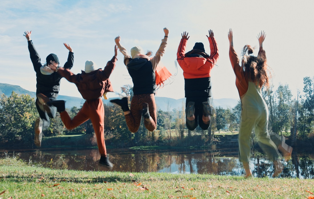 Friends jump and campingare happy on Incentive Trips with water for funweekend travel group